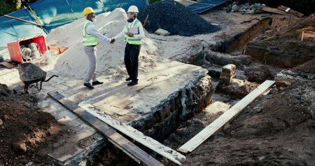 Construction site, handshake and engineer people in partnership outdoor to start foundation. Mature men, foreman or employees from above for excavation, agreement or collaboration and shaking handsの写真素材