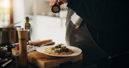 Spices, food and hands of chef with plate in kitchen of home for diet, private service or cooking. Ingredients, recipe and closeup of person seasoning dish for gourmet cuisine, meal flavor or lunchの写真素材