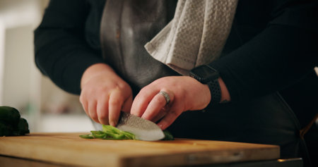 Chef, hands and man in kitchen, cutting vegetables and nutrition with meal prep, culinary skills and ingredients. Closeup, home or expert with utensils, cook and chopping board with recipe or cuisineの写真素材