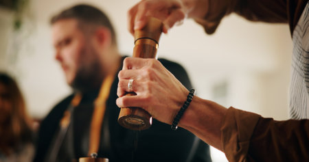 People, hands and chef with shaker for seasoning food, spice or adding flavor in kitchen at home. Closeup, culinary artist or hospitality with ingredient for taste, new recipe or condiment at houseの写真素材