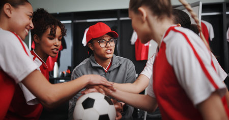 Women, coach and hands together with soccer ball for teamwork, motivation or collaboration in locker...