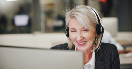 Mature woman, computer and smile with call center consultant, communication or help desk support at. Happy, telecom and female person with online advice, customer service and outbound consultingの写真素材