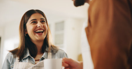 Drinking, laughing and couple with coffee in kitchen for bonding, connection or conversation together. Happy, love and man with woman for enjoying caffeine beverage in morning with talking in home.の写真素材