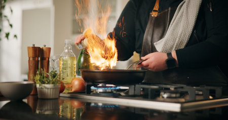 Cooking, flame and man with hands, home and frying pan with fire, wellness and ingredients. Closeup,...