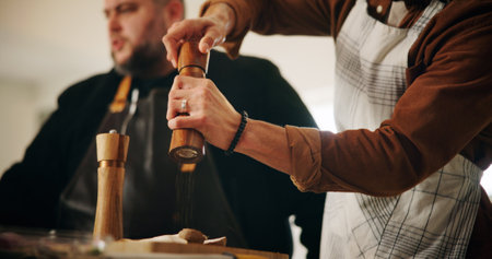 Cooking class, chef and hands of person with spices for food flavor, meal preparation or learning recipe. Culinary course, closeup and seasoning for dinner lesson with nutrition or cuisine in kitchenの写真素材
