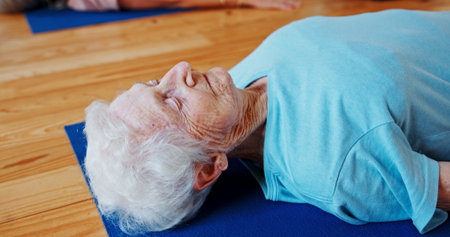 Relax, meditation and senior woman in class for calm, wellness and mindfulness in retirement. Peace, health and elderly female person with breathing on yoga mat for holistic healing, zen or balance.の写真素材