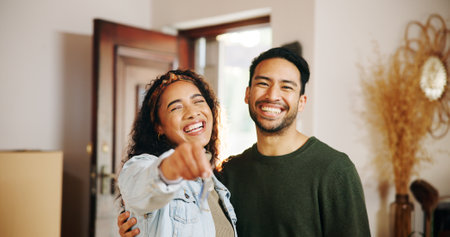 Couple, smile and keys with new home, moving in and finance investment together. Excited man, woman and happy with property, real estate or house for mortgage loan, renovation and relocation successの写真素材