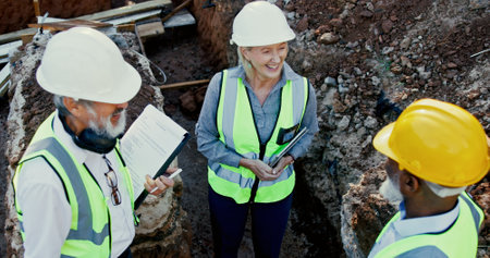 Engineering, people and happy on construction site for meeting, discussion and problem solving in foundation. Woman inspector, above team and smile on worksite for planning, project progress and techの写真素材
