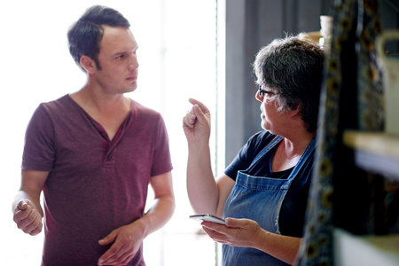 Business people, discussion and ceramic workshop with planning, smartphone and conversation with...