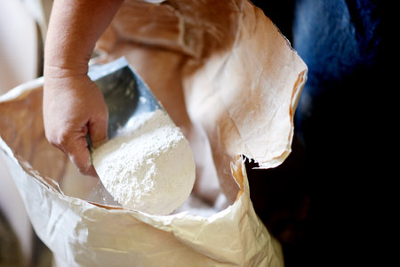 Pottery, powder and hand of potter in workshop for manufacturing, clay production and small business. Ceramics, studio and person with scoop for measurement, preparation and creativity in startupの写真素材