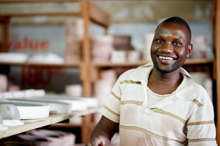Portrait, potter and man with smile, creative and confident for ceramic workshop, art and entrepreneur. Small business, artisan and person with skills for sculpture, talent and production in Kenyaの写真素材