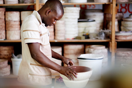 Black man, pottery and bowl in workshop for ceramics, handcraft or artistic skills for small business. Entrepreneur, artist or male potter with creativity, handmade manufacturing or productionの写真素材