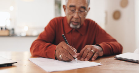 Senior man, finance and writing with documents for retirement funding, tax and compliance in home. Elderly person, signature and paperwork for pension, budget and review for investment at apartmentの写真素材