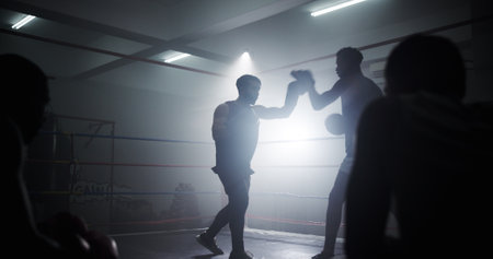 Learning, team and health with men in boxing ring for sparring practice, boxer training and fitness coaching. Mma club, sports and martial arts fighter with people in gym for personal trainerの写真素材
