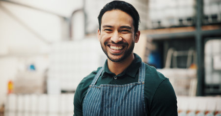 Manufacturing, portrait and smile of man in distillery for fermentation or production of beer. Apron, factory and small business with happy brewer at industrial plant for alcohol bottling processの写真素材