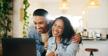 Kitchen, couple and hug with laptop for laughing, support and bonding together with online shopping....