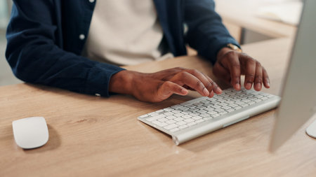 Graphic designer, computer or hands on keyboard in office with online review, project update or...