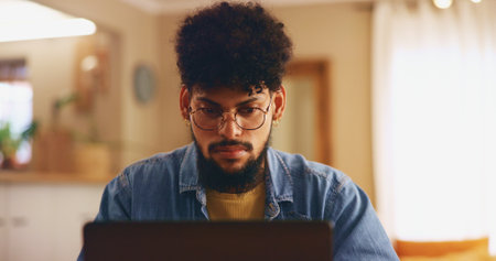 Home, man and glasses with laptop for remote work, copywriting and solution for news story. House, freelancer and editor with digital for problem solving, proofreading and website for blog articleの写真素材
