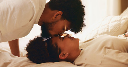 Relax, couple and forehead kiss in bedroom, home and bonding for relationship, commitment and apartment. Resting, man and affection for woman, happy people and smile for romance in morning or loveの写真素材