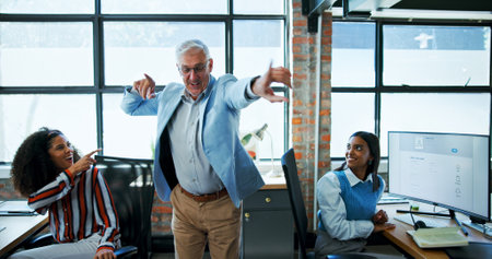 Dance, energy or music and boss in office with employee team for celebration or milestone. Business, excitement and having fun with happy design manager in creative workplace for success or targetの写真素材