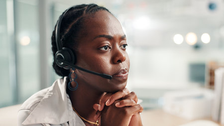 Black woman, consultant or concern with headset at call center for bad news or difficult customer. Female person, agent or employee thinking with mic in worry for negative feedback or error at officeの写真素材