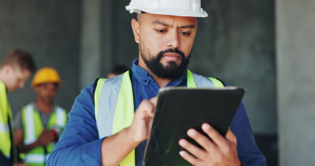 Building, inspection and tablet with construction worker man on site for civil engineering or development. App, digital plan and thinking with developer person on location for project managementの写真素材