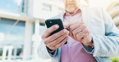 Business, hands and man in city, smartphone and texting with social media, connection and internet. Person, closeup or entrepreneur with cellphone, outdoor or digital app for ride service or locationの写真素材