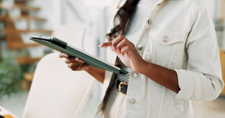 Hands, woman and typing on tablet in office for research, schedule update and review newsletter. Female journalist, digital and editing article, story information and feedback of magazine publicationの写真素材