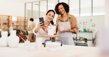 Pottery class, selfie and women in ceramic workshop with online post, achievement and clay product. Phone, social media or mentor in studio with support, feedback and sculpture design mold or smileの写真素材