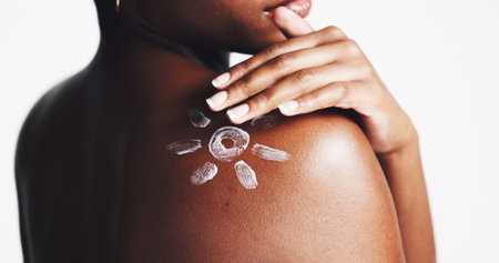 Sunscreen, shoulder and cream with woman in studio for sun protection, skincare and uv ray safety. Beauty, self care and dermatology with closeup of person on white background for spf benefitsの写真素材