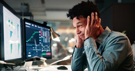 Man, trading and computer with stress for charts with value crash, results or monitor for stocks at office. Person, frustrated and crypto investor at night by screen, worry and lost revenue at agencyの写真素材
