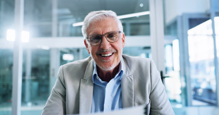 Business, video call and man in office, speaking and online meeting with presentation for profit growth. Mature person, employee or professional in workplace, smile and virtual seminar for investmentの写真素材