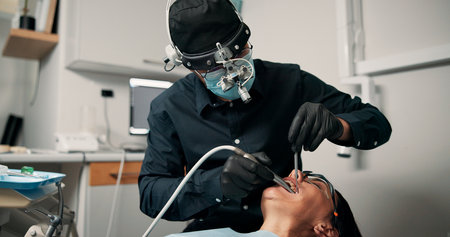 Appointment, medical procedure and woman with dentist in office for healthcare or mouth operation. Checkup, dental hygiene or oral exam with person and medicine professional at clinic for dentistryの写真素材