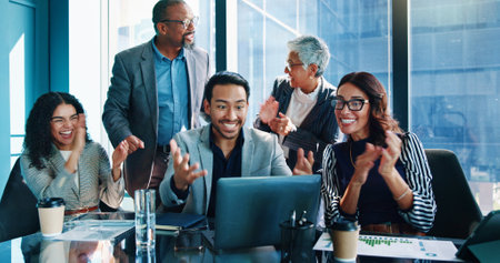 Laptop, excited and business people in office, financial success and stock market with applause. Clapping, pc or employees with profit growth, celebration or budget report for company revenue and wowの写真素材