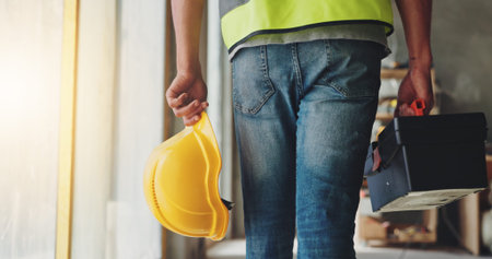 Construction, hands and walking with toolbox, helmet and safety compliance for industrial...