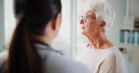 Sad woman, doctor and talking in hospital, healthcare and consultation with support, cancer diagnosis and calm. Stress, senior patient or medical with help, test results and wellness with feedbackの写真素材