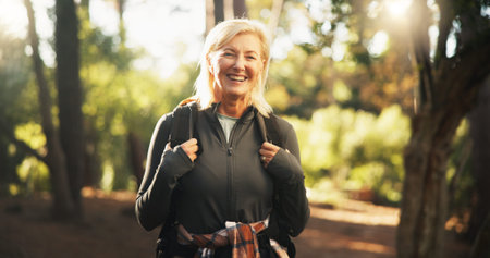 Portrait, senior and happy woman hiking in woods for holiday, travel or vacation on adventure....