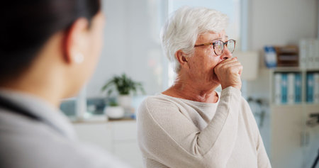 Sad woman, doctor and crying with healthcare, shocked and consultation with support, empathy and tears. Pensioner, old patient and medical with professional, results and sympathy with help and cancerの写真素材