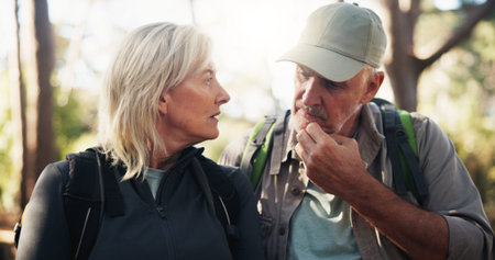 Senior couple, hiking and talking for route direction and tourism on holiday with travel decision....