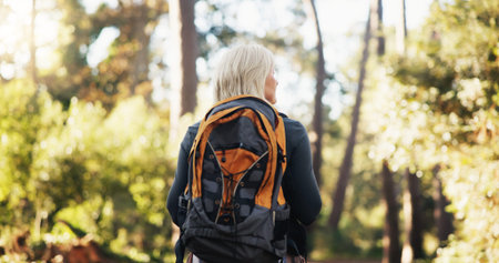 Nature, backpacking and senior woman hiking with travel, adventure or journey on vacation. Outdoor,...