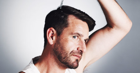 Hair, serum and growth with man in studio for oil, self care and scalp health treatment. Beauty,...
