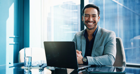 Portrait, smile and Asian businessman on laptop for finance, investment and opportunity with actuary. Computer, corporate professional and happy employee in office with confidence as risk analystの写真素材