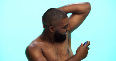 Black man, spray or deodorant for armpit with hygiene in studio, fragrance or grooming with cosmetic...