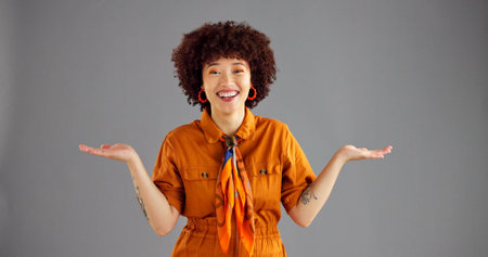 Portrait, open hands and woman with smile, choice and selection on grey studio background. Face, person and model with gesture, questions and shrug with decision, mockup option and offer with opinionの写真素材