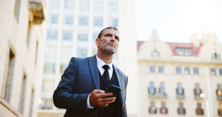 Businessman, phone and waiting in city for taxi, cab ride or transportation to travel. Man, employee...
