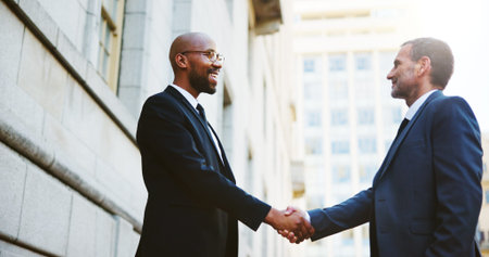 Happy, business people or men in city, handshake or agreement with B2B deal. Contract, employees or...