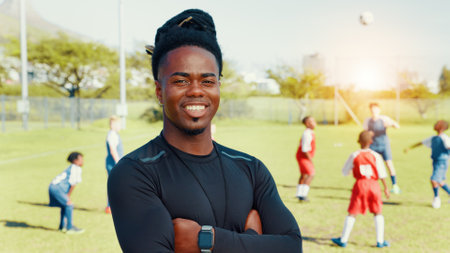 Portrait, coach and man with arms crossed, soccer and confident for training routine, happy or outdoor. Sports field, trainer and person with smile in morning, proud and fitness for football or matchの写真素材
