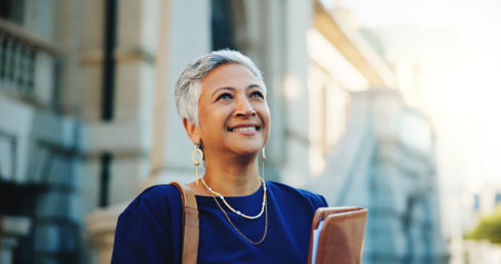 Lawyer, documents and thinking with business woman in city for court case files, trial assessment and attorney brief. Plead agreement, legal research and advocate paperwork with mature person outdoorの写真素材