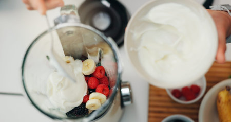 Fruit smoothie, hands and yogurt in blender for breakfast shake, meal replacement and healthy...
