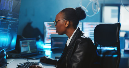 Hacker, coding and woman with computer, night and data for cyber espionage, system and phishing in office. Online, programming and person with tech for ransomware, spy and hacking for fraud or scamの写真素材